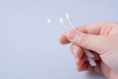 A few ear sticks in hand isolated on white background