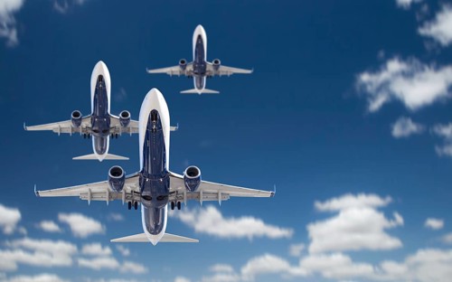 Bottom view of three passenger airplanes flying in the blue sky