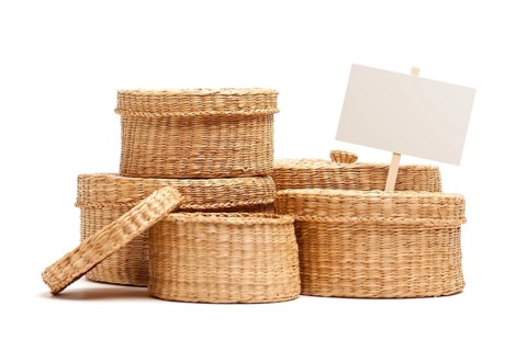 Various sized wicker baskets with blank sign isolated on white