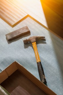 Hammer and block with new laminate flooring abstract