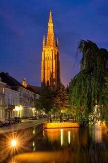 Church of Our Lady and canal illuminated in the night. Brugge Bruges