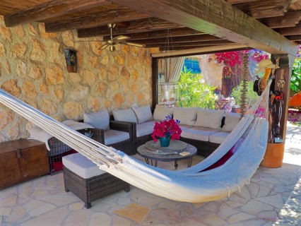 Covered wooden veranda with seating area and hammock