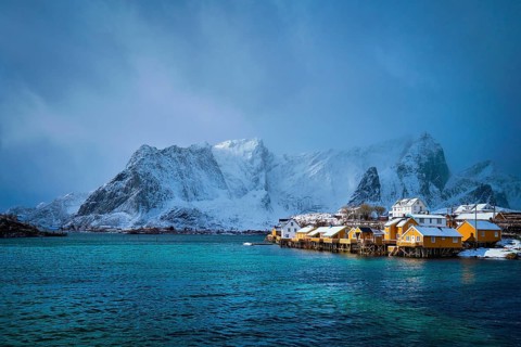 Yellow rorbu houses of Sakrisoy fishing village with snow in winter. Lofoten islands
