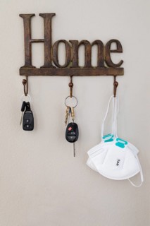 Home key hanger rack next to door with keys and medical face mask during coronavirus pandemic