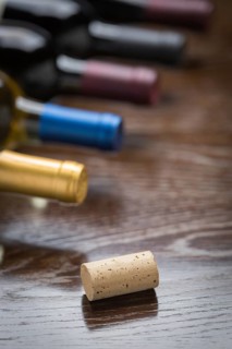 Wine bottles and cork on a reflective wood surface abstract