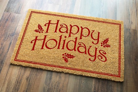 Happy holidays christmas tad welcome mat on wood floor background