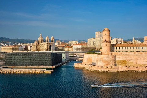 Marseille Old Port and Fort Saint-Jean and Museum of European and Mediterranean Civilisations and Marseille Cathedral on sunset with passing boat