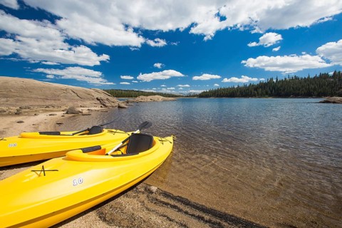 Pair of yellow kayaks on a beautiful mountain lake shore