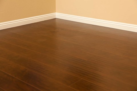 Beautiful newly installed brown laminate flooring and baseboards in home