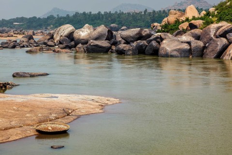 Traditional wickerwork coracle boat in Hampi on bank of Tungabhadra river