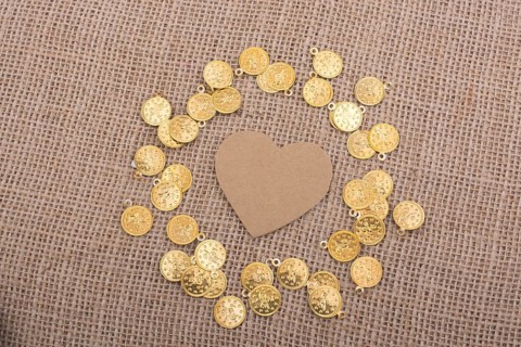 Fake gold coins around heart shape made of paper