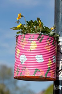 Colourfully painted tin can as a flower pot