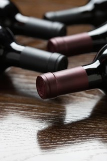Various wine bottles on a reflective wood surface abstract