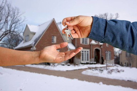 Handing over the house keys in front of a beautiful new home