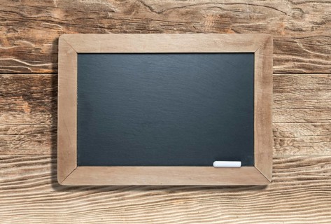 Blank slate black chalkboard with chalk on aged wood background