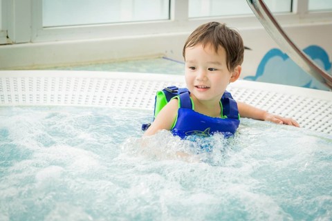 Adorable mixed-race boy having fun at the water park