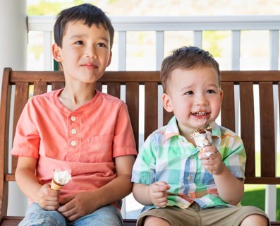 Young mixed-race chinese and caucasian brothers enjoying their ice cream cones
