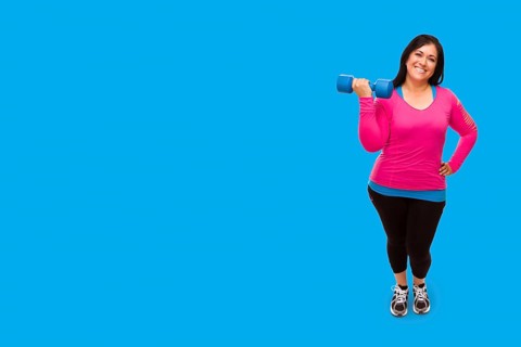Middle aged hispanic woman in workout clothes holding dumbbell against A bright cyan blue background