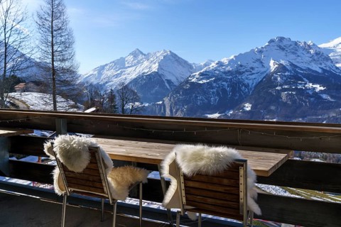 Chairs with fur on balcony in front of mountain panorama