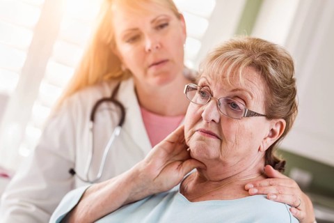 Melancholy senior adult woman being consoled by female doctor or nurse