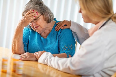 Female doctor consoling distraught senior adult woman