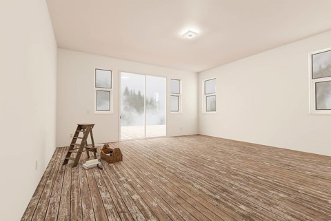 Ladder and painting equipment in raw unfinished room of house with blank white walls and worn wood floors