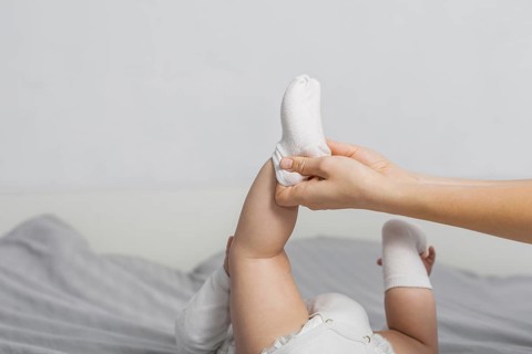 Baby putting socks