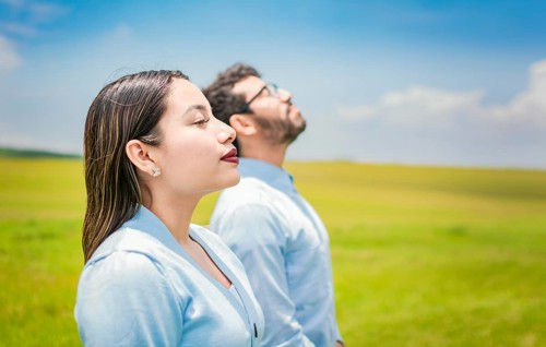 Young couple breathing fresh air in the field