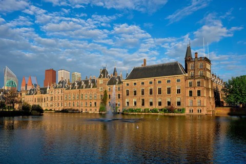 View of the Binnenhof House of Parliament and the Hofvijver lake with downtown skyscrapers in background. The Hague