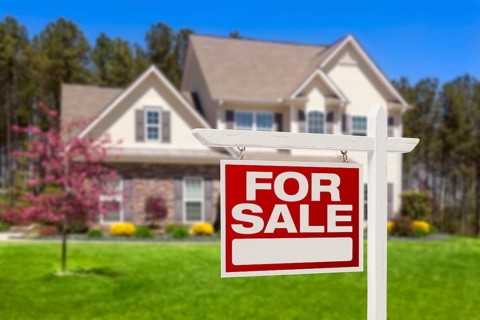 Home for sale real estate sign and beautiful new house