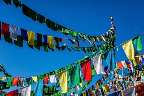 Buddhist prayer flags lungta with Om Mani Padme Hum Buddhist mantra prayer meaning Praise to the Jewel in the Lotus on kora around Tsuglagkhang complex. McLeod Ganj