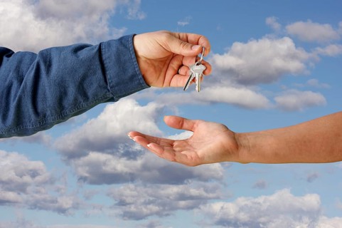 Handing overe the keys over a beautiful sky