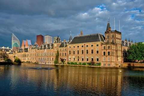 View of the Binnenhof House of Parliament and the Hofvijver lake with downtown skyscrapers in background