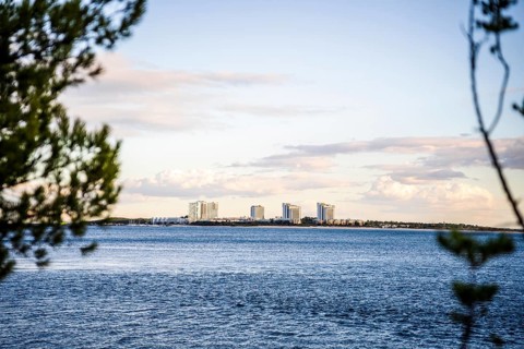 Cityscape of Troia by sunset with Atlantic ocean and trees in the foreground