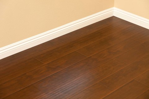 Beautiful newly installed brown laminate flooring and baseboards in home