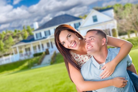 Playful young military couple outside A beautiful new home