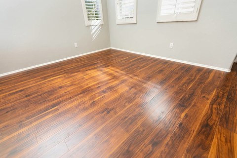 Newly installed brown laminate flooring and baseboards in home