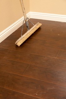 Push broom on a newly installed laminate floor and new baseboards