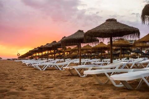 Beautiful colorful sunset over sun beds and umbrellas in Vilamoura