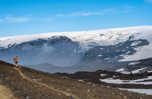 Hikers on trail through volcanic landscape