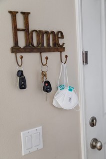 Home key hanger rack next to door with keys and medical face mask during coronavirus pandemic