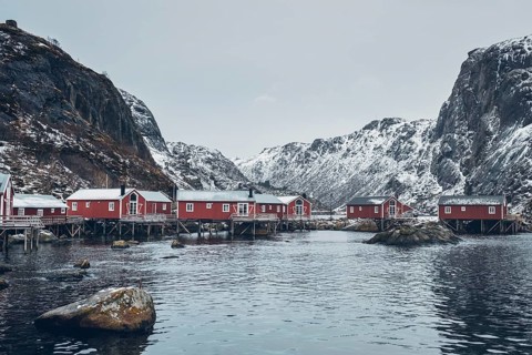 Nusfjord authentic traditional fishing village with traditional red rorbu houses in winter in Norwegian fjord. Lofoten islands