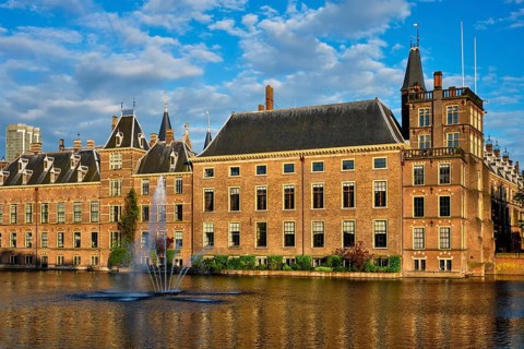 View of the Binnenhof House of Parliament and the Hofvijver lake with downtown skyscrapers in background. The Hague