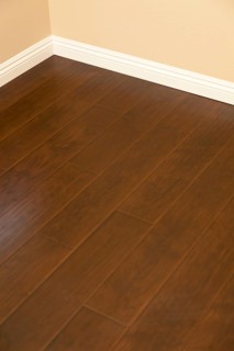 Beautiful newly installed brown laminate flooring and baseboards in home