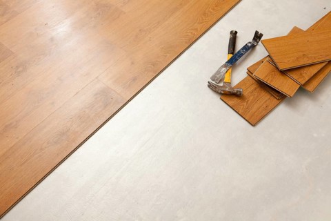 Worn hammer and pry bar with laminate flooring abstract with copy room