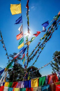 Buddhist prayer flags lungta with Om Mani Padme Hum Buddhist mantra prayer meaning Praise to the Jewel in the Lotus on kora around Tsuglagkhang complex