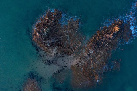 Aerial view of rock formations in the sea in front of the sandy beach Ker Emma shortly in front of sunset