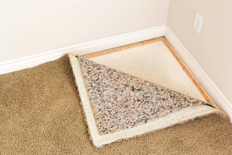 Pulled back carpet and underlay in room of house