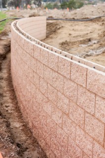Curved new outdoor retaining wall being built at construction site
