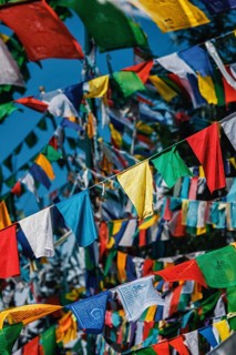 Buddhist prayer flags lungta with Om Mani Padme Hum Buddhist mantra prayer meaning Praise to the Jewel in the Lotus on kora around Tsuglagkhang complex